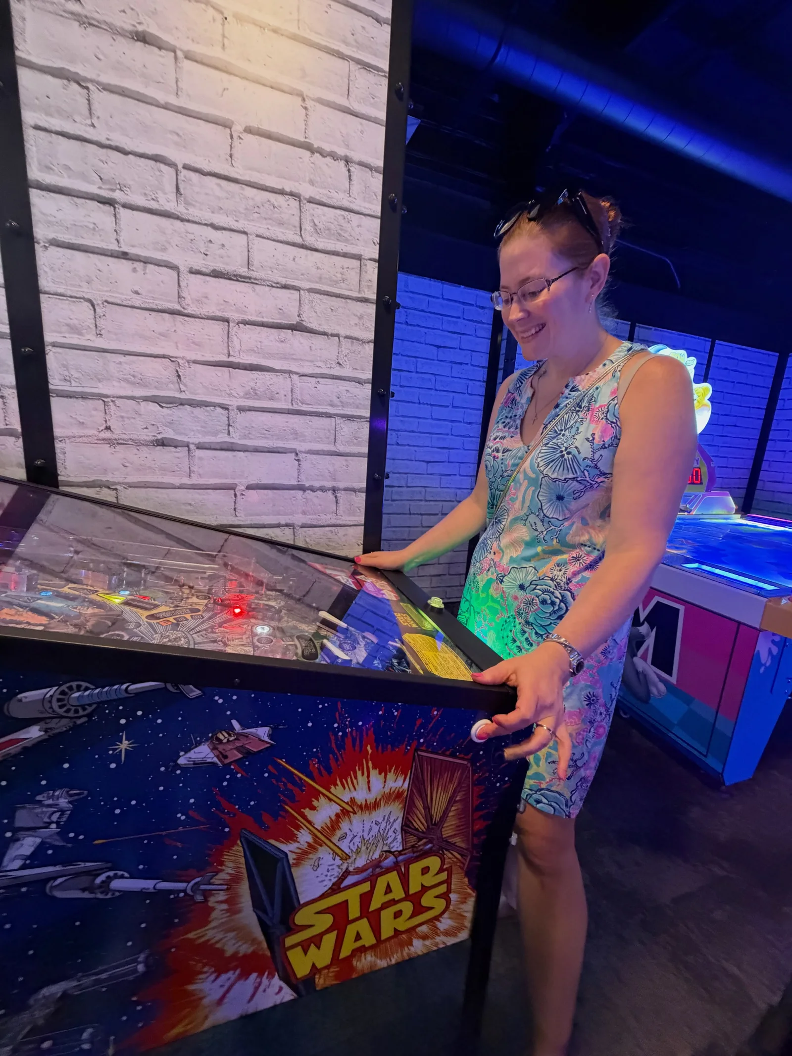 Victoria playing pinball in the arcade on board her cruise