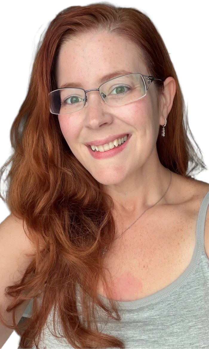 Victoria Carles smiling with fresh skin and long red hair