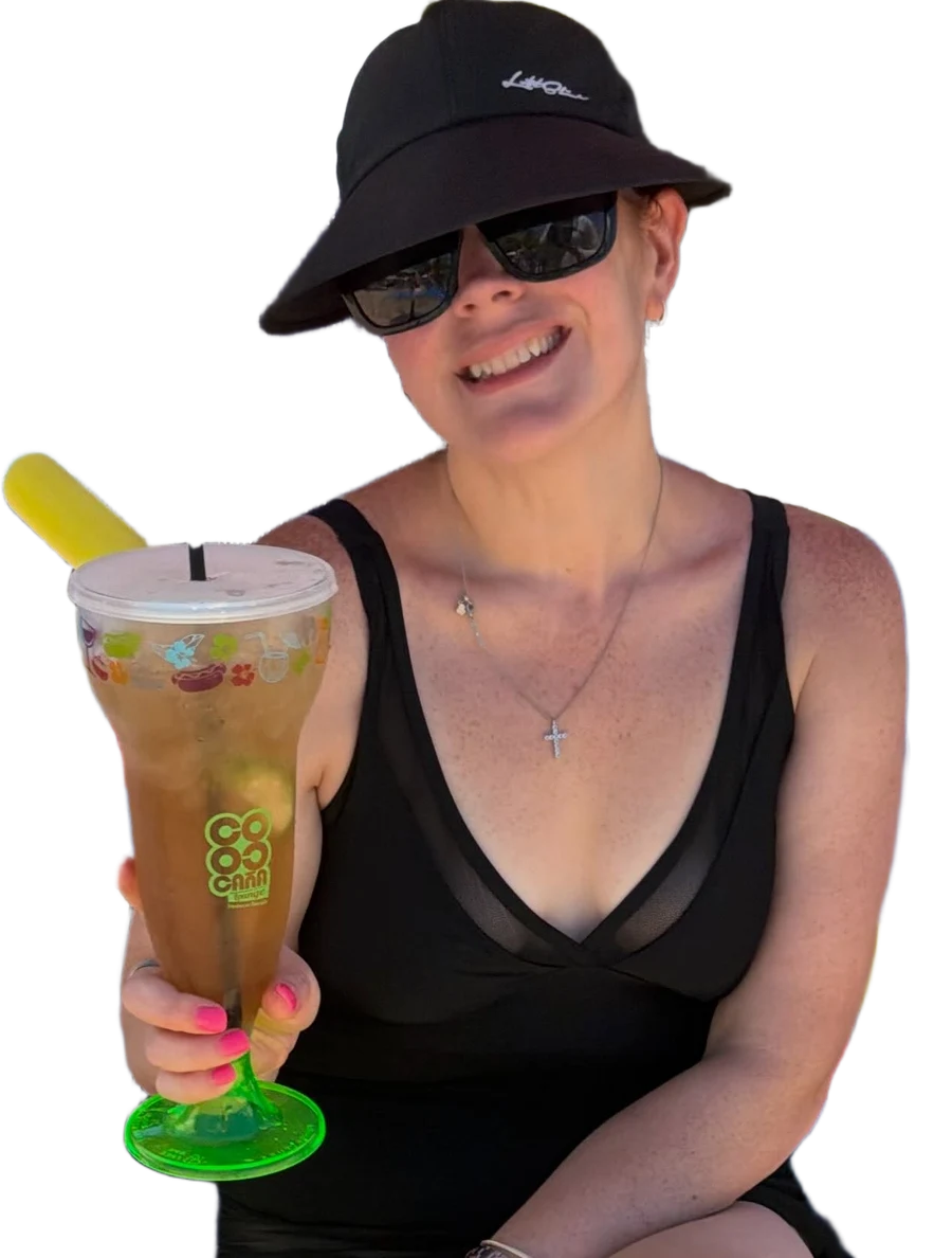 Victoria raising a tropical drink on vacation
